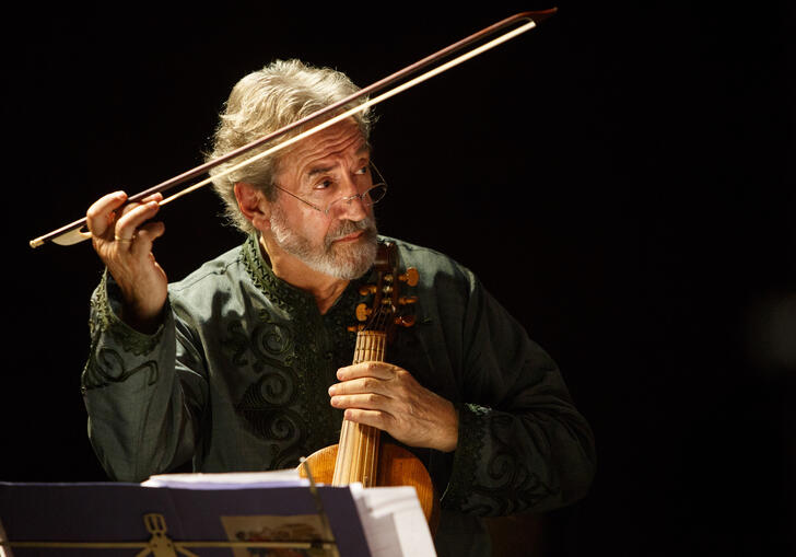 Jordi Savall holding a treble viol, directing with his bow