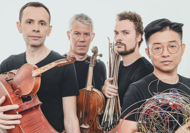 Quatuor Diotima holding broken instruments. 
