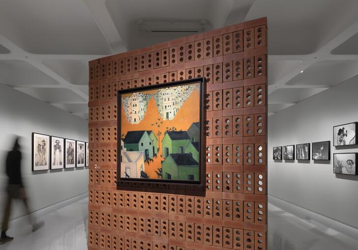 orange painting on a brick wall in a gallery