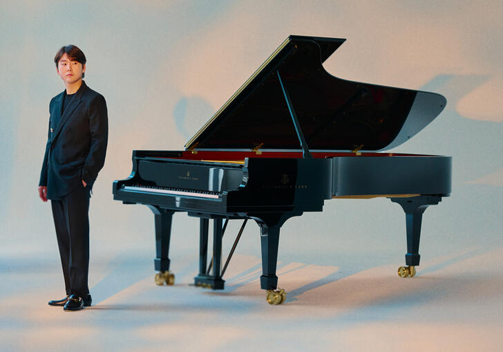 Seong-Jin Cho standing next to a piano