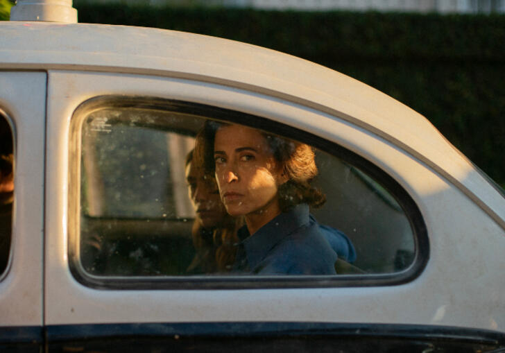 Eunice sits in the back of a police car 