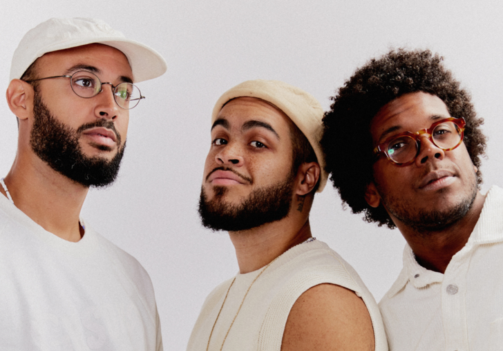Three black men. members of Gilsons, dressed in white 