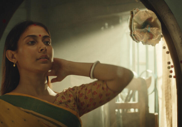 Maloti stares into a mirror, bathed in soft light