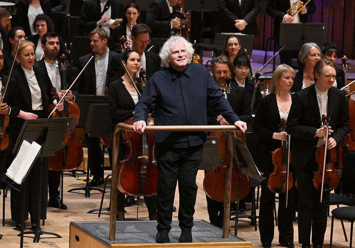 Sir Simon Rattle facing the audience in the Barbican concert hall