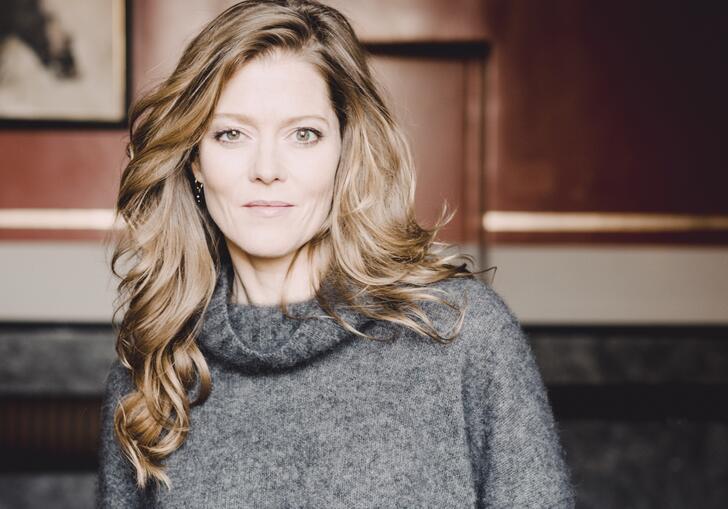 A portrait photo of Barbara Hannigan, wearing a grey jumper and facing the camera