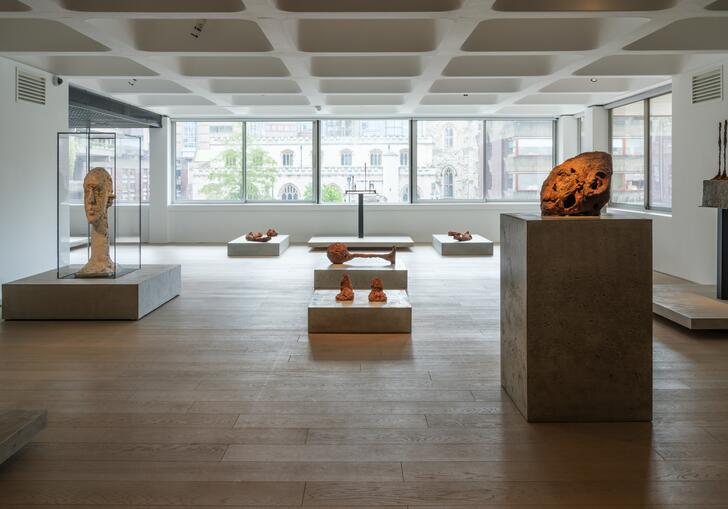 A shot of the Level 2 gallery showing works by Huma Bhabha and Alberto Giacometti on concrete plinths.