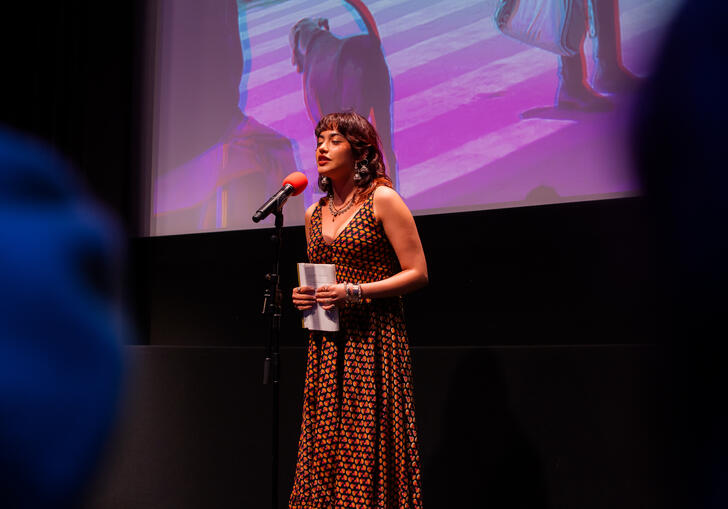 A young woman performing poetry on stage