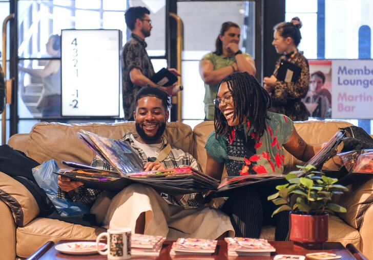 Two people sitting at a sofa