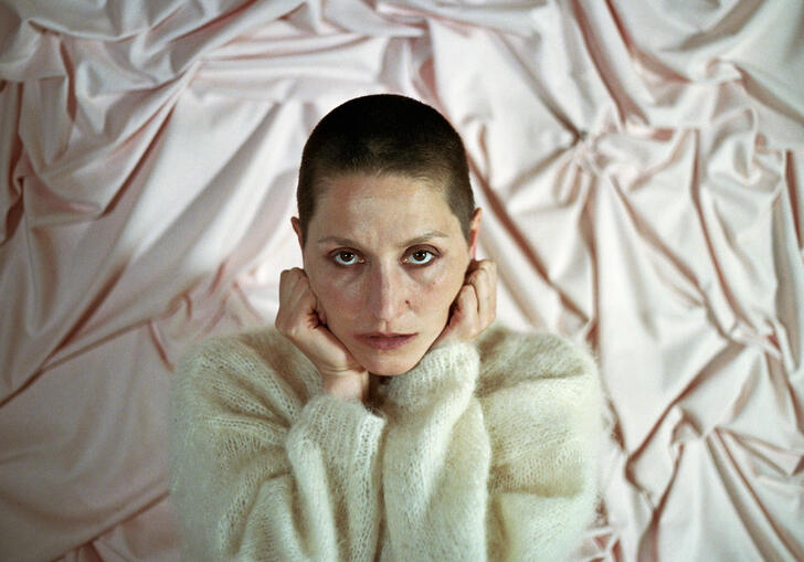 Image of Cate Le Bon with her hands on her head