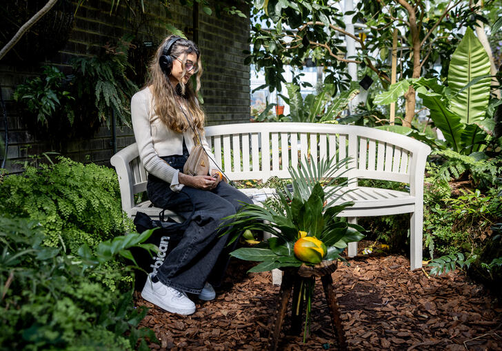 A person sitting on a bench wearing headphones