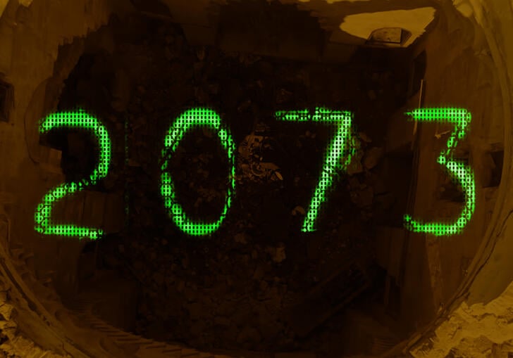 Green writing spells out 2073 over a pile of rubble