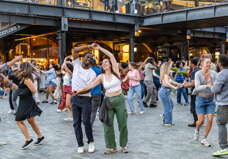 A group of people dance smiling