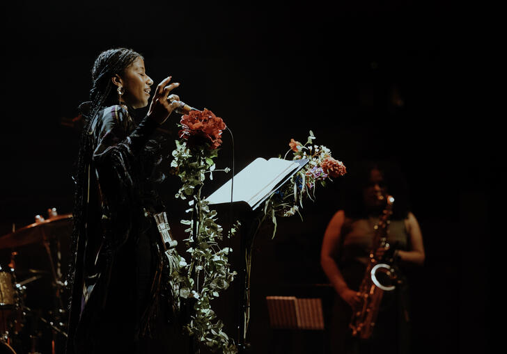 aja monet singing in front of a jazz band