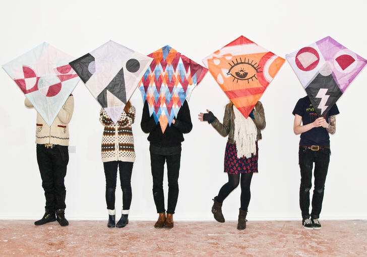 Five people stand in a line and pose with their kimono kite creations.