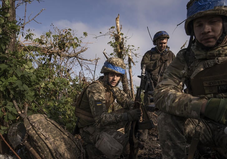 A group of soldiers sit in a field