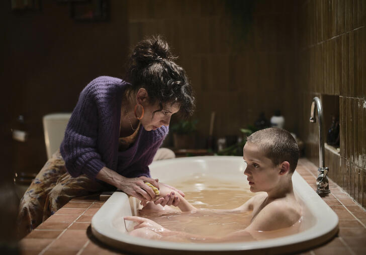 A woman and a child who is in a bathtub.