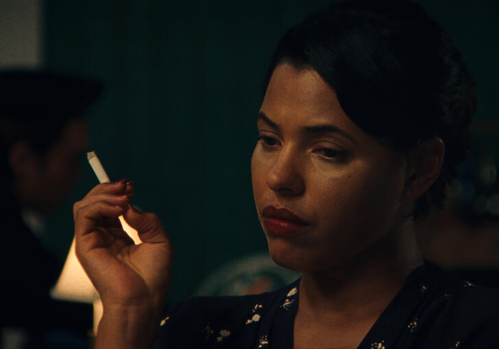 A woman sadly smokes a cigarette