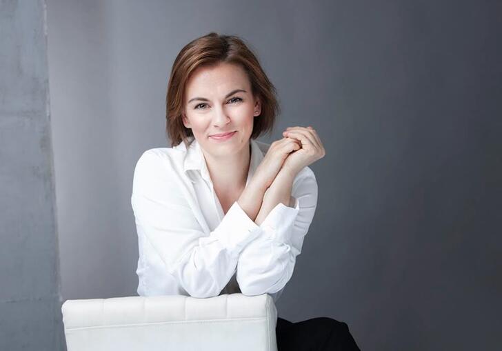 Conductor Daniela Candillari wearing white shirt with hands clasped