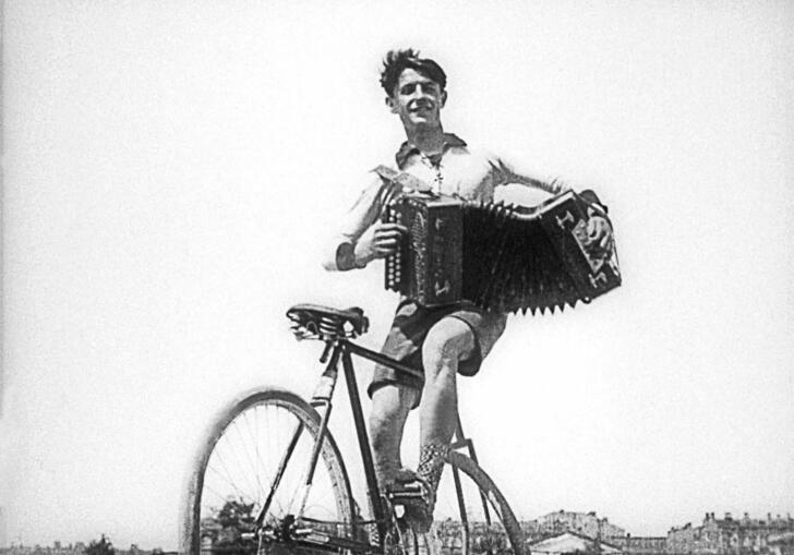 Man on bicycle with accordion