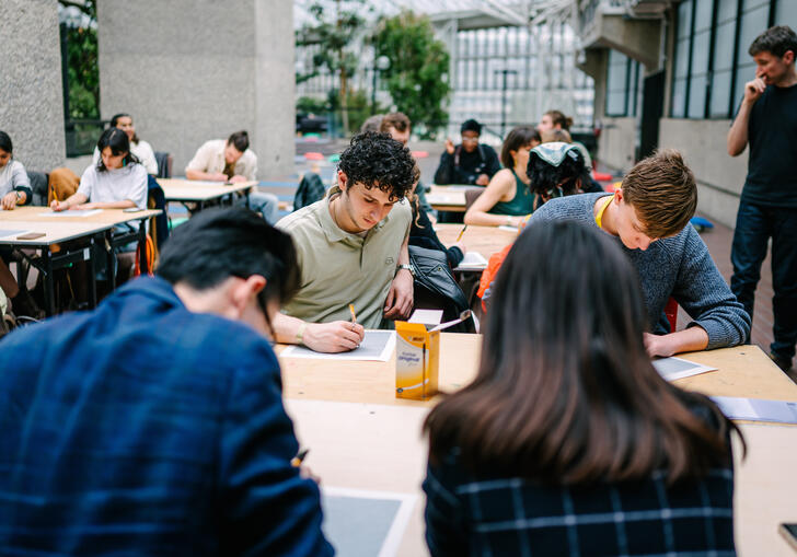A group of people drawing, engaged in a workshop