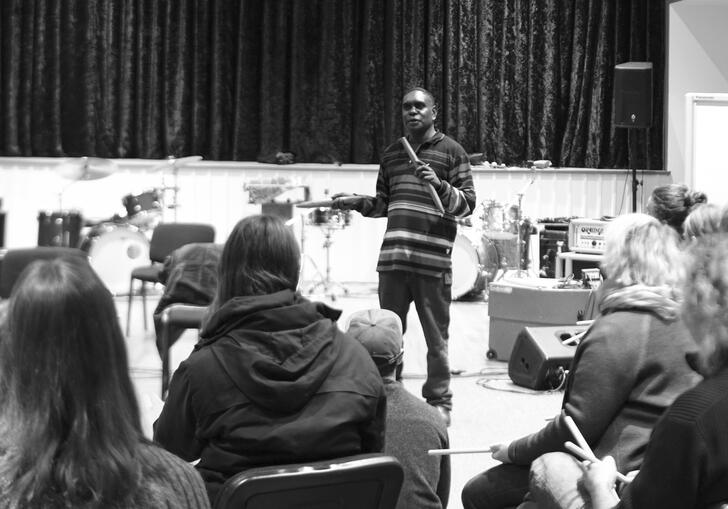 A black and white photo of a flute performer in front of an audience