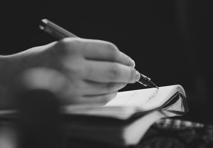 A hand writing in a book 