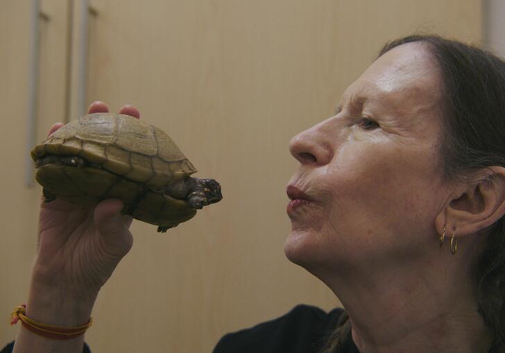 A women holding a turtle.