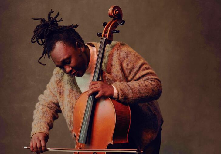 Abel standing and playing the cello