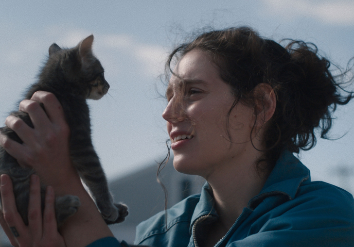 A young woman holds a small kitten