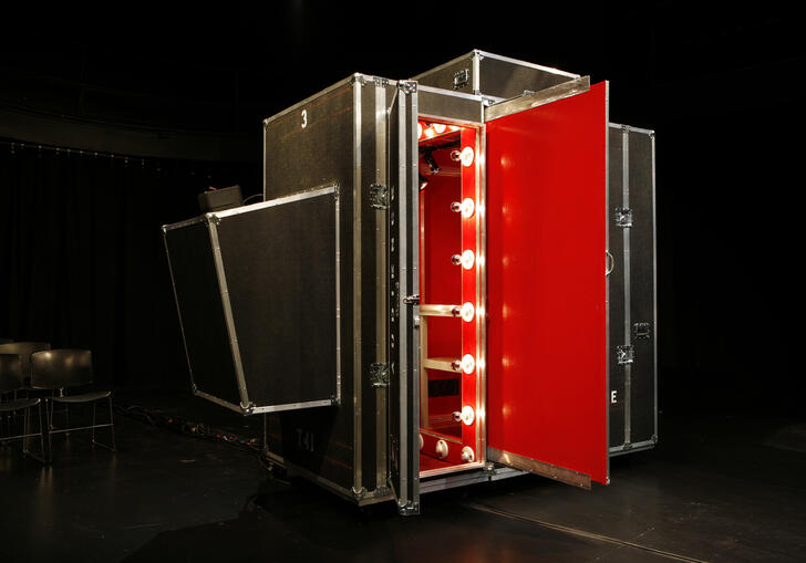 The theatre for one pop-up booth, a photo of a black and red container with show lights.