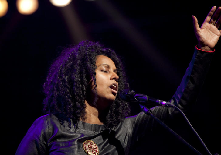 Susheela Raman singing and raising her hand to the sky