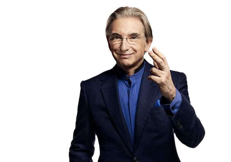 Photo of Michael Tilson Thomas wearing a black suit and blue shirt