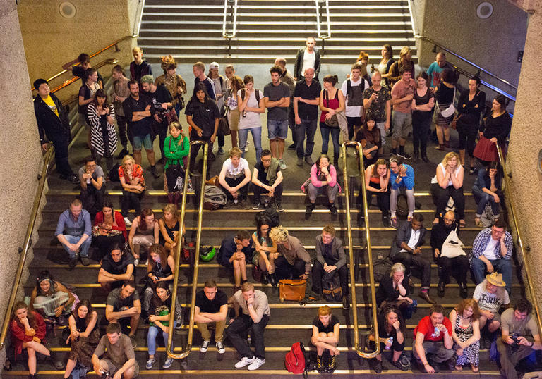 Photo of visitors watching a performance on the stairs