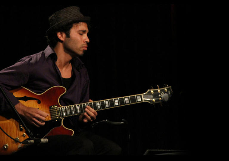 Photo of man playing a guitar