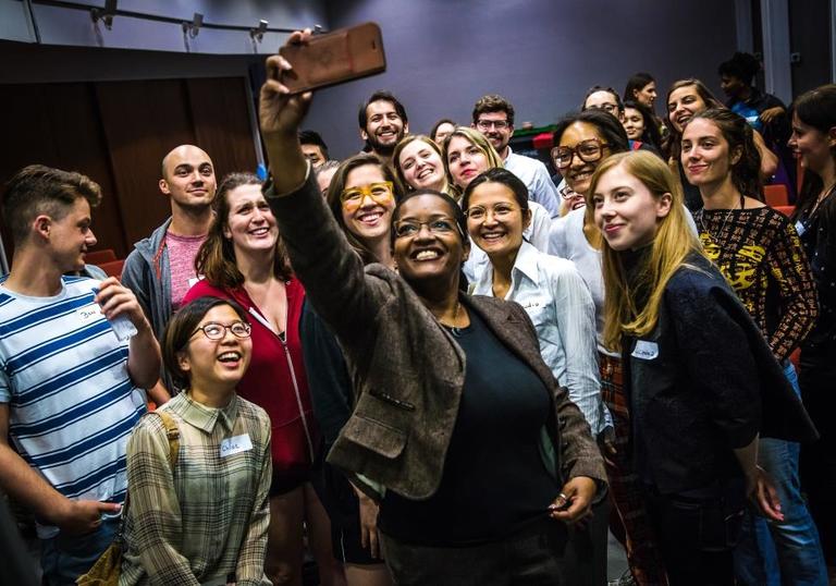 Photo woman taking selfie of group of young people