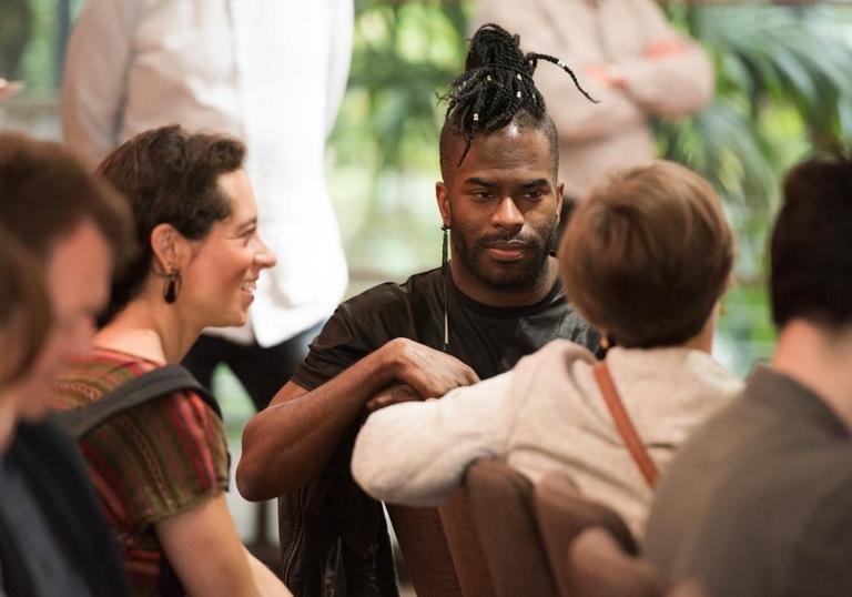 Photo of man with dreadlocks in the crowd at a symposium