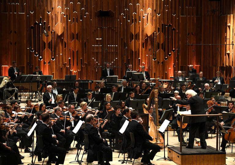 Photo of Sir Simon Rattle conducting the London Symphony Orchestra in the Barbican Hall