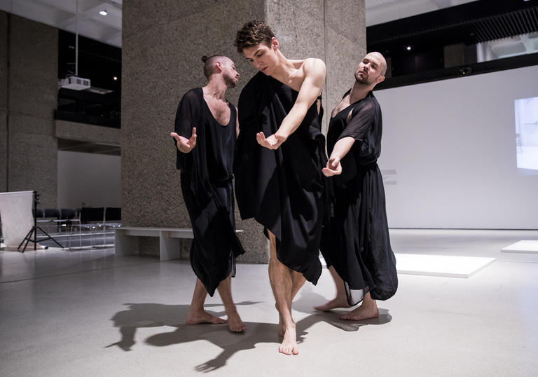 Photo of three men in robes dancing in Trajal Harrell