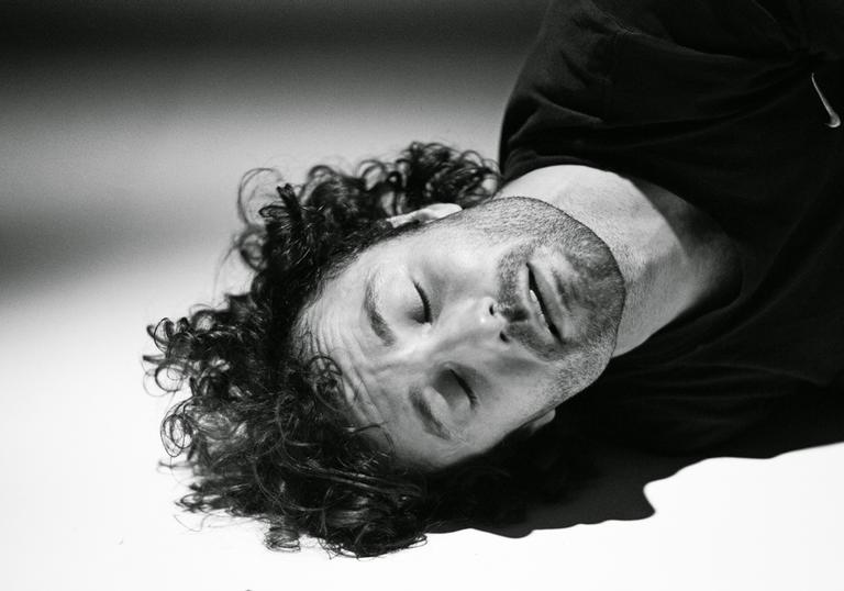 Man rests head on floor in black and white
