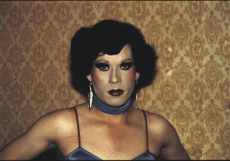 Gazing directly into the camera, Paz Errazuriz’s arresting photograph of Pilar, a cross-dresser working in an underground brothel in Chile during the 1980s.