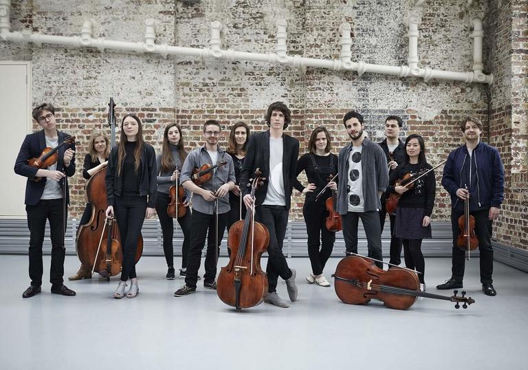 12 ensemble holding posing with their stringed instruments