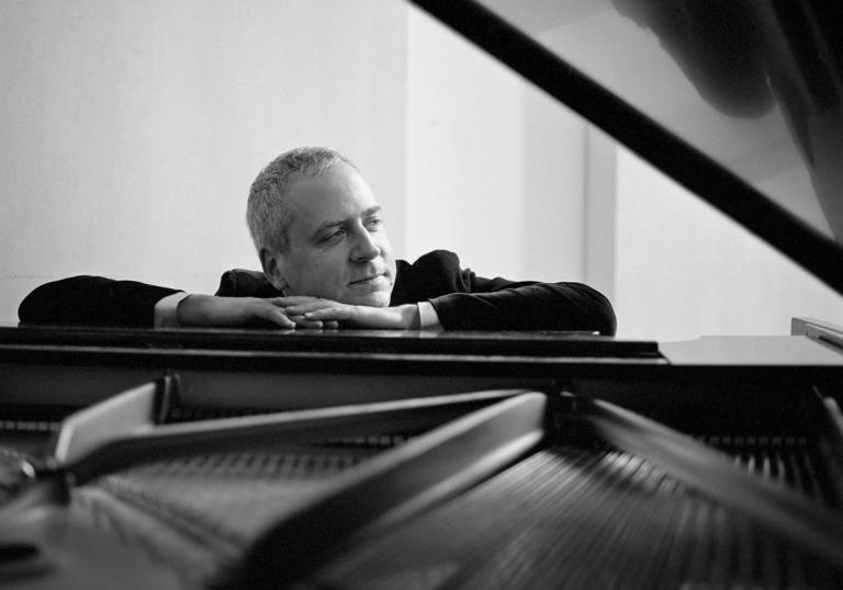 Jeremy Denk sitting at piano landscape B&W