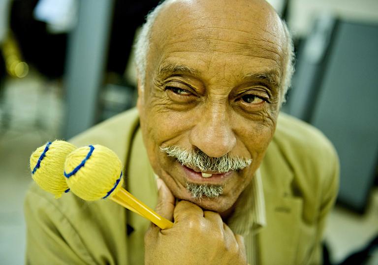 Mulatu Astatke poses with a flamboyant drum stick