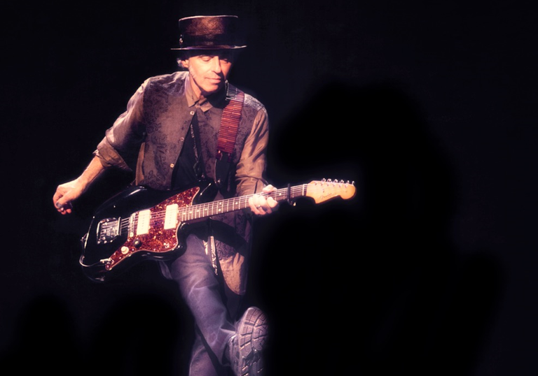 Nils Lofgren pulling over the impressive feat of kicking and playing guitar simultaneously 