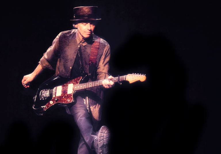 Nils Lofgren pulling over the impressive feat of kicking and playing guitar simultaneously