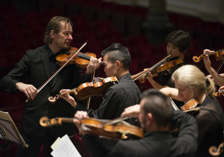 ACO and Tognetti on stage playing 