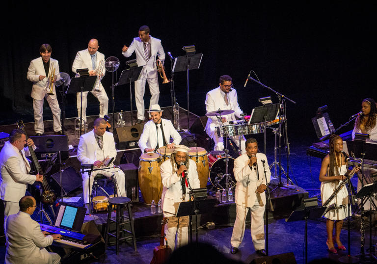 Afro-Cuban All Stars playing music all dressed in white suits