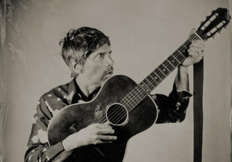 Gruff Rhys with an acoustic guitar