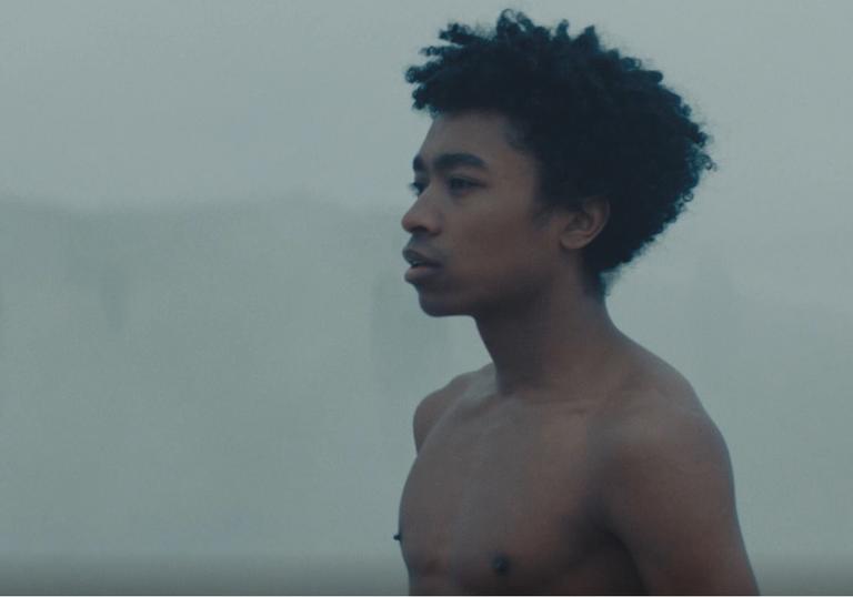 a man standing on a misty beach