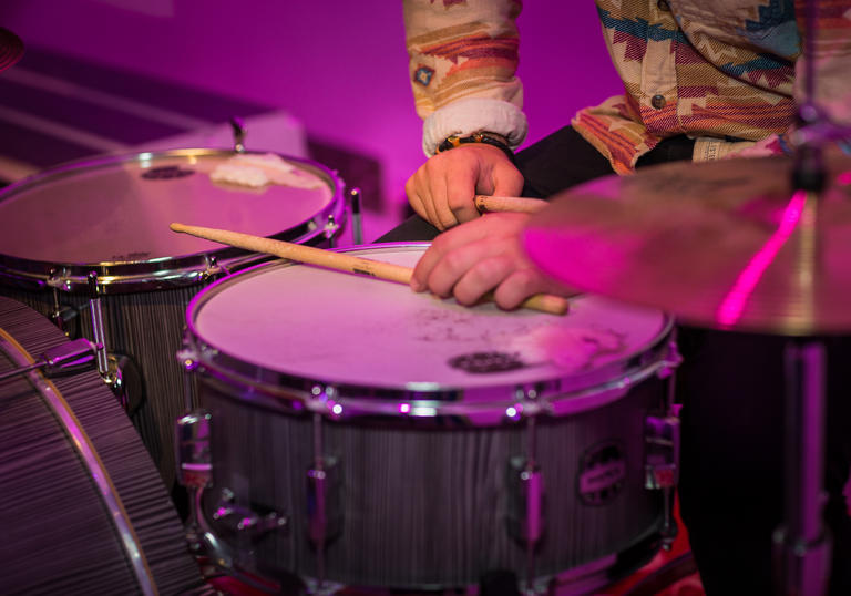 two drums with drumsticks held by a drummer